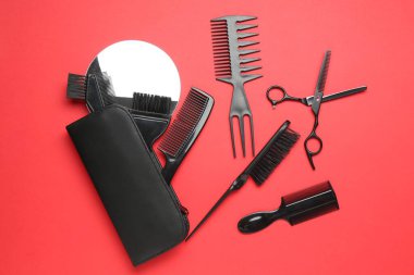 Kırmızı arka planda farklı kuaför aletleri, düz yatıyordu