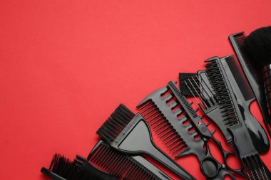 Kırmızı arka planda farklı kuaför aletleri var. Metin için boşluk