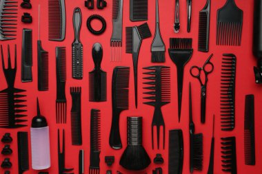Kırmızı arka planda farklı kuaför aletleri, düz yatıyordu