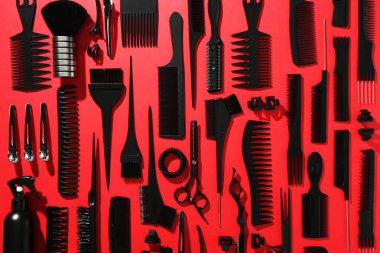 Kırmızı arka planda farklı kuaför aletleri, düz yatıyordu