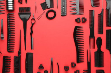 Kırmızı arka planda farklı kuaför aletleri çerçevesi, düz. Metin için boşluk