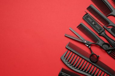 Kırmızı arka planda farklı kuaför aletleri var. Metin için boşluk