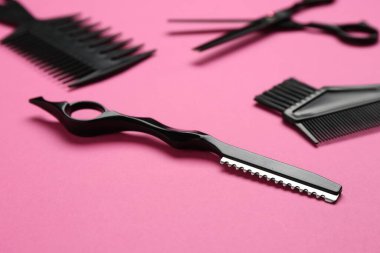 Pembe arka planda farklı kuaför araçları, yakın plan