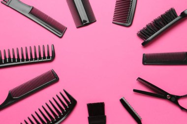 Farklı kuaför aletlerinin çerçevesi pembe arka planda, düz yerde. Metin için boşluk