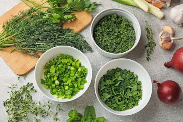 Gri masada farklı taze otlar ve baharatlar var.