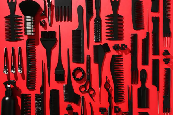 Kırmızı arka planda farklı kuaför aletleri, düz yatıyordu
