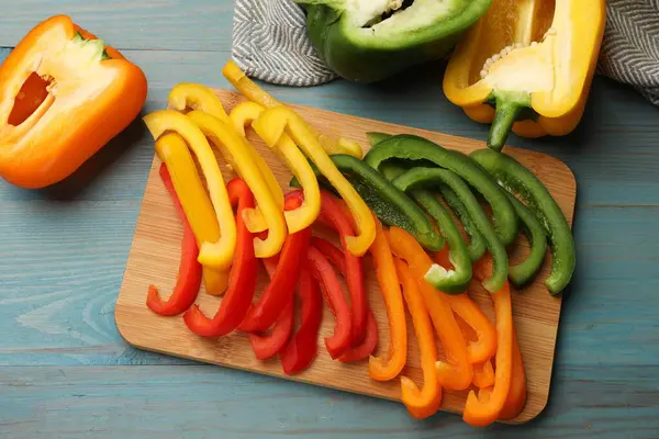 Mavi ahşap masada renkli dolmalık biberler, düz yatıyordu.