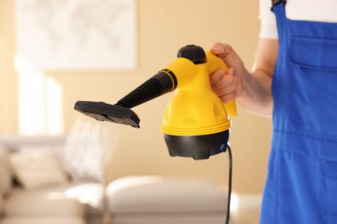 Evde buhar temizleyicisi olan kapıcı, yakın çekim.