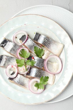 Beyaz masada baharatlı ve soğanlı lezzetli ringa balıkları.