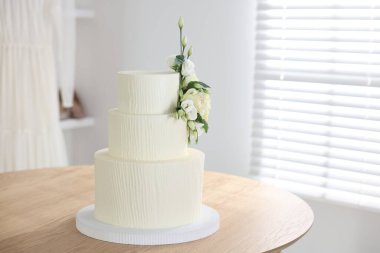 İçerideki ahşap masada çiçek desenli nefis düğün pastası.