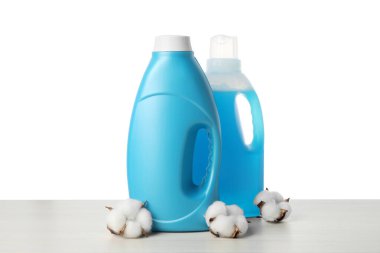 Beyaz arka plana karşı ahşap masada yumuşatıcı ve pamuk çiçekleri.