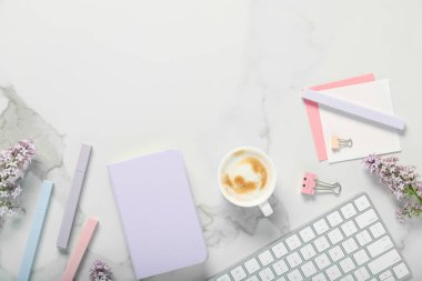 Kırtasiyeli düz kompozisyon, beyaz mermer masa üzerinde kahve ve çiçekler. Metin için boşluk