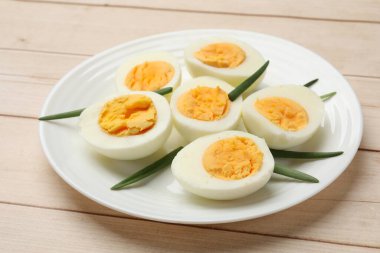 Haşlanmış yumurta ve yeşil soğan ahşap masada, yakın plan.