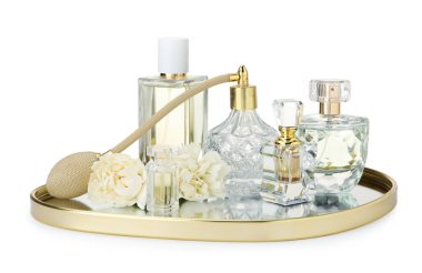 Birçok farklı parfüm şişeleri ve çiçekler beyaz üzerine izole edilmiş.