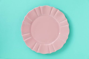 Turkuaz arka planda boş bir tabak, üst görünüm