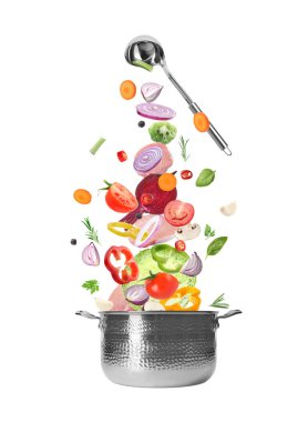 Taze sebze ve et beyaz arka planda tencereye düşüyor.