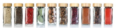 Beyaz arka planda cam kavanozlarda farklı baharatlar, set