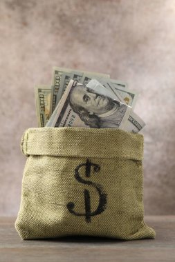 Tahta masanın üzerinde dolar banknotları olan çanta.