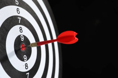 Hedef alınıyor. Siyah arkaplanda ok olan dart tahtası, yakın plan