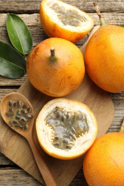 Olgun çarkıfelek meyveleri, tohumlar ve yeşil yapraklar ahşap masada, düz yatıyordu.