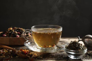 Bitki çayı ve kuru yaprakları ahşap masaya serpmek, yakın çekim. Metin için boşluk