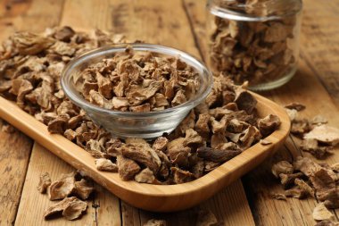 Kuru hindiba kökleri kasede ve kavanozlar ahşap masada, yakın plan.