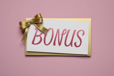 Pembe arka planda altın fiyonklu bonus kart, üst manzara