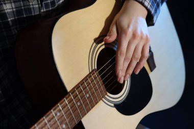 Siyah arka planda gitar çalan kadın, yakın plan