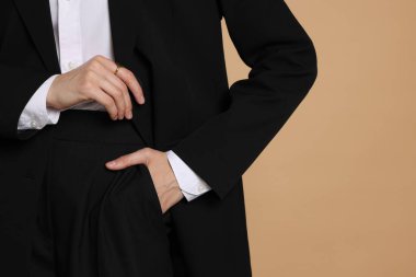 Bej arka planda takım elbiseli kadın, yakın plan. Metin için boşluk
