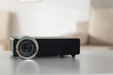 Beyaz masa üzerinde modern video projektörü, yakın plan.