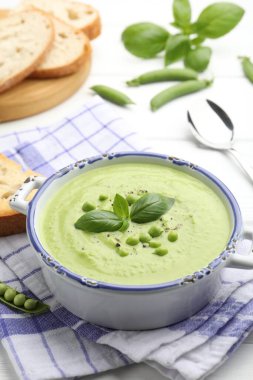 Beyaz masada fesleğenli bezelye kremalı çorba.