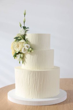 İçerideki ahşap masada çiçek desenli nefis düğün pastası.