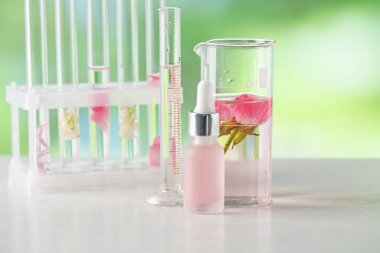 Lüks parfüm yapıyorum. Esasen cam yağlar ve beyaz ahşap masa üzerinde çiçekler bulanık arka plan, yakın çekim