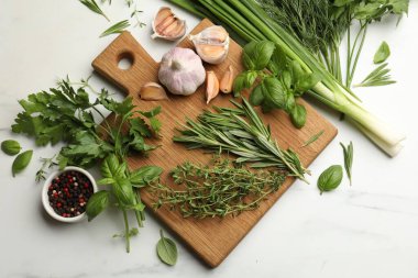 Farklı taze otlar ve baharatlar beyaz mermer masada, düz yatıyordu.