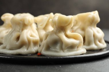 Siyah masadaki baharatlı lezzetli khinkali, yakın plan.