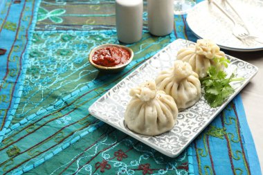 Gri masada soslu kişniş ve kişniş ile servis edilen lezzetli khinkali, metin için yer