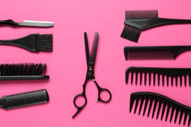 Pembe arka planda farklı kuaför aletleri, düz yatış