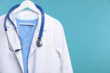 Üzerinde steteskop olan doktor ceketi mavi arka planda, yakın plan. Metin için boşluk