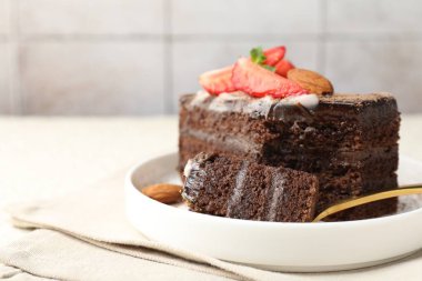 Masada çilekli ve bademli bir dilim lezzetli çikolatalı pasta, yakın plan. Metin için boşluk