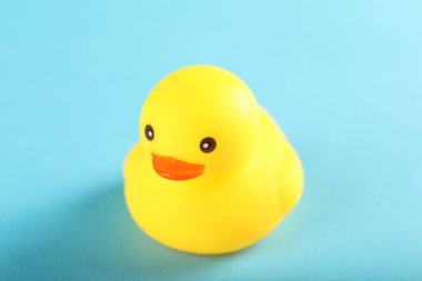 Açık mavi arkaplanda sevimli bir lastik ördek, yakın plan.