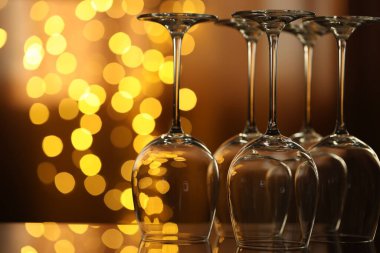 Bulanık ışıklara karşı cam ayna yüzeyinde birçok temiz bardak var. Bokeh etkisi