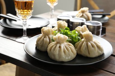 Nefis khinkali kişniş ve şarapla servis edilir ahşap masada, yakın plan.