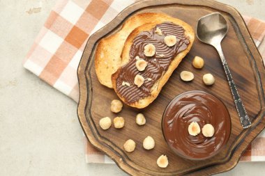 Lezzetli çikolatalı tostlar ve fındıklar ışık masasında.