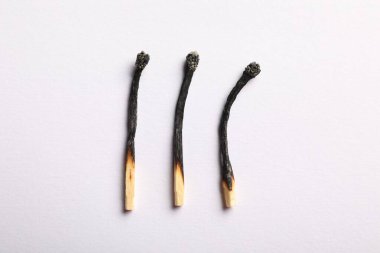 Açık gri arkaplanda yanmış kibritler, düz yatış