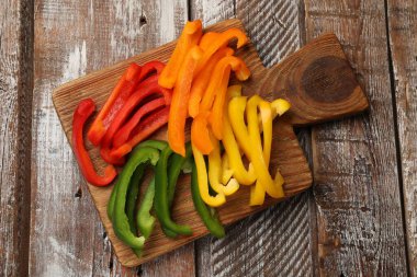 Ahşap masada renkli dolmalık biberler, üst manzara.