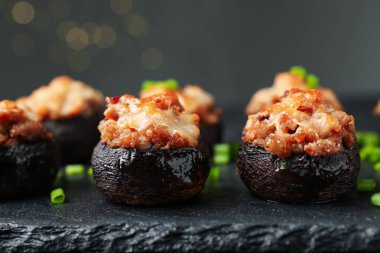 Siyah masada servis edilen lezzetli mantarlar bulanık arka plan, yakın plan