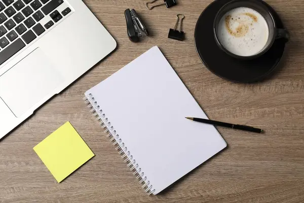 Defter, diğer kırtasiye malzemeleri, kahve ve dizüstü bilgisayar ahşap masa, düz uzanma