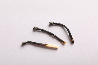 Açık gri arkaplanda yanmış kibritler, düz yatış