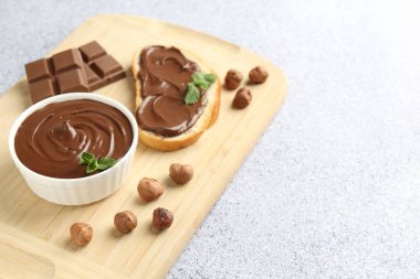 Lezzetli çikolata, tost, fındık ve nane şekeri. Gri desenli masa, yakın plan. Metin için boşluk