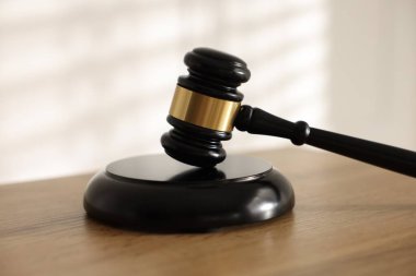 Hakimin tokmağı ahşap masada, arka planda ışığa karşı, yakın plan.